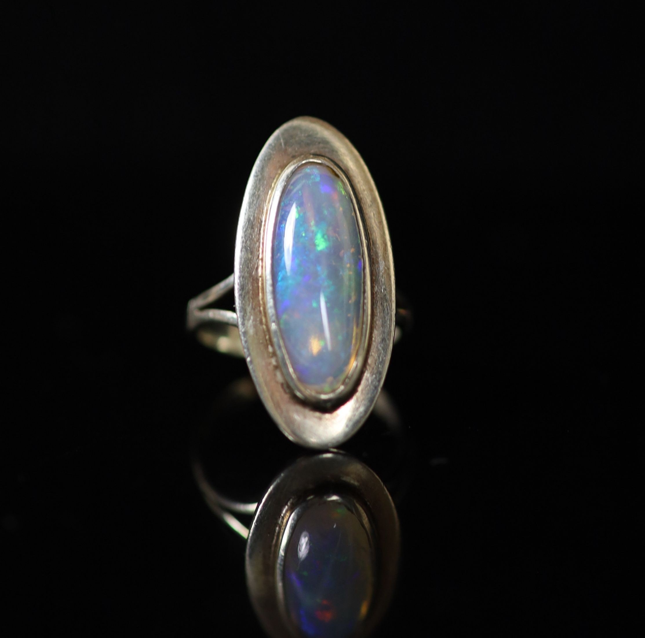 A 9ct white gold and oval cabochon white opal set dress ring